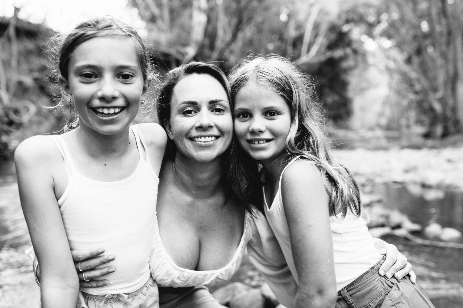 Black and white portrait series of children playing and laughing together outdoors.