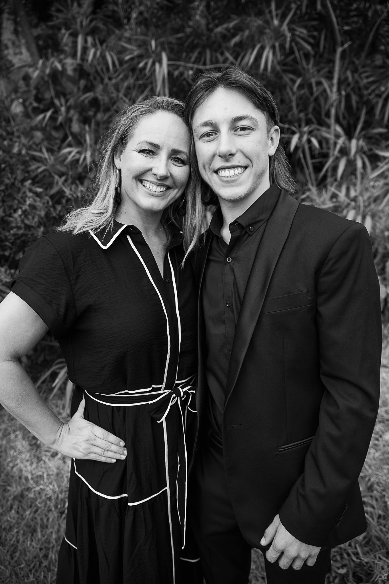 Black and white portraits showing joyful moments against natural foliage.