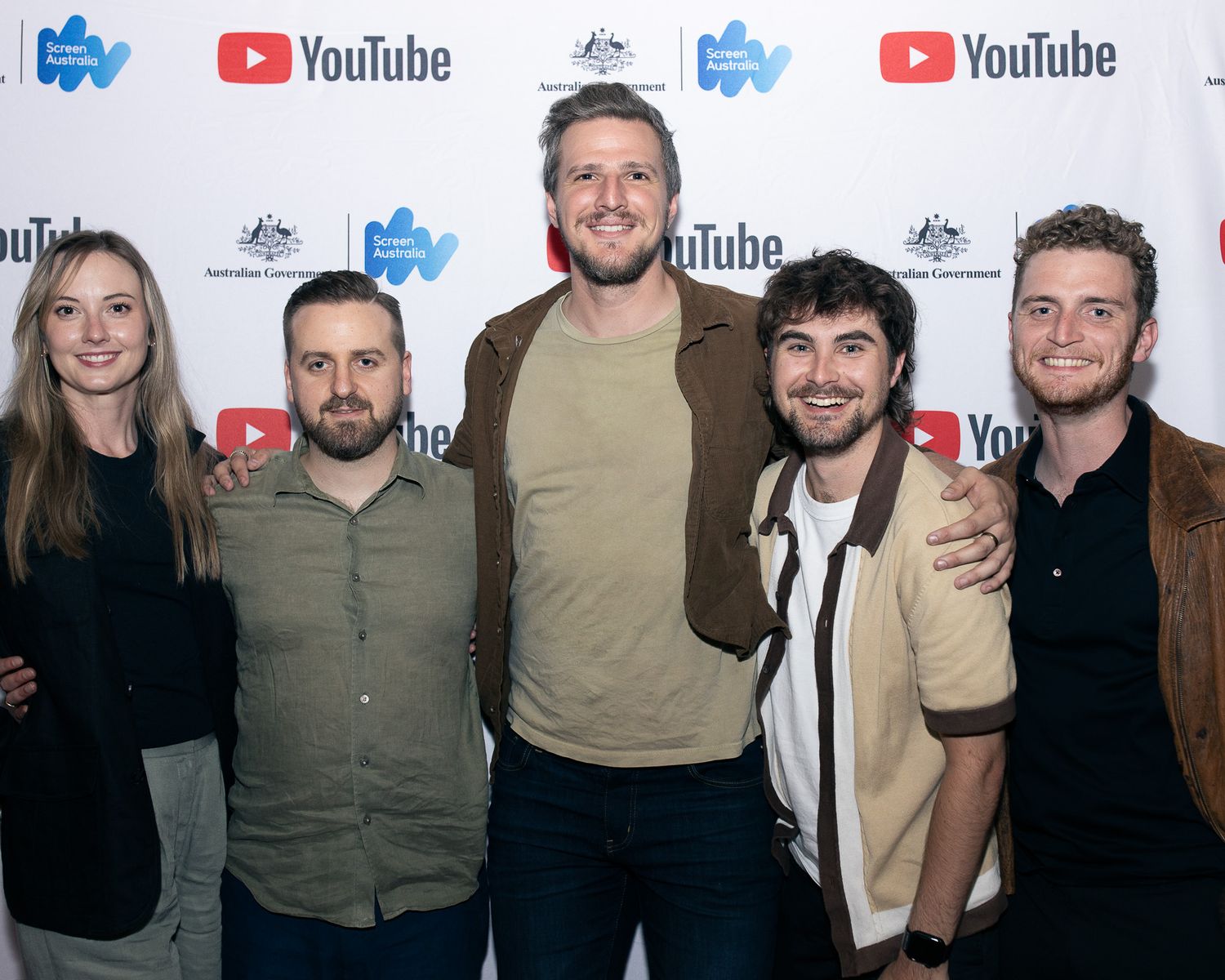 Group photo of attendees at a YouTube event standing in front of branded step-and-repeat backdrop.