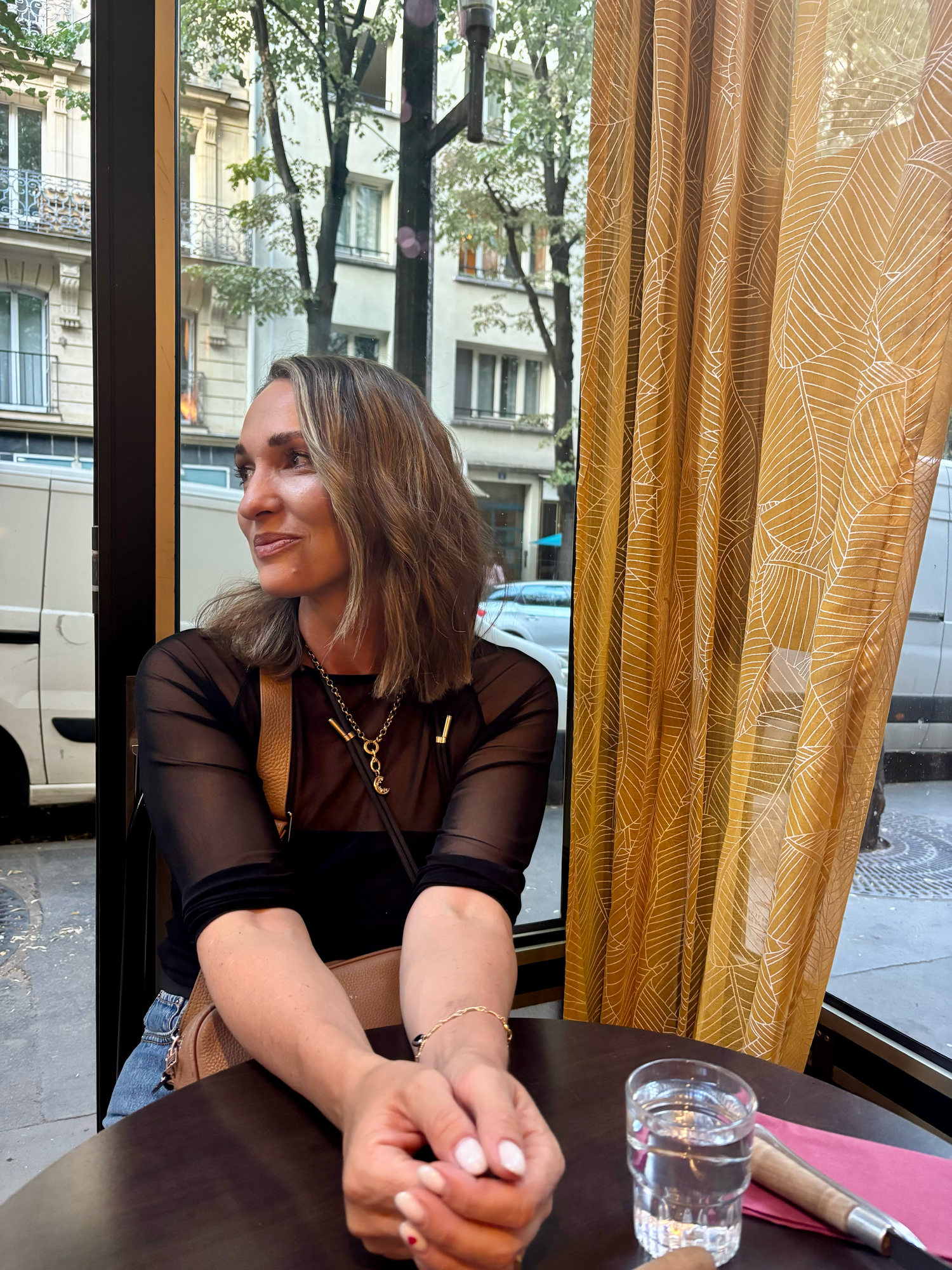 Series of candid shots showing someone sitting at a cafe table near a window with curtains.