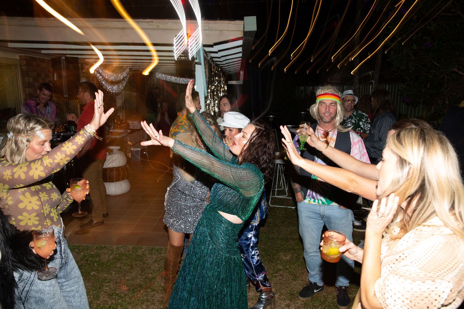 People dancing and celebrating at an outdoor evening event.
