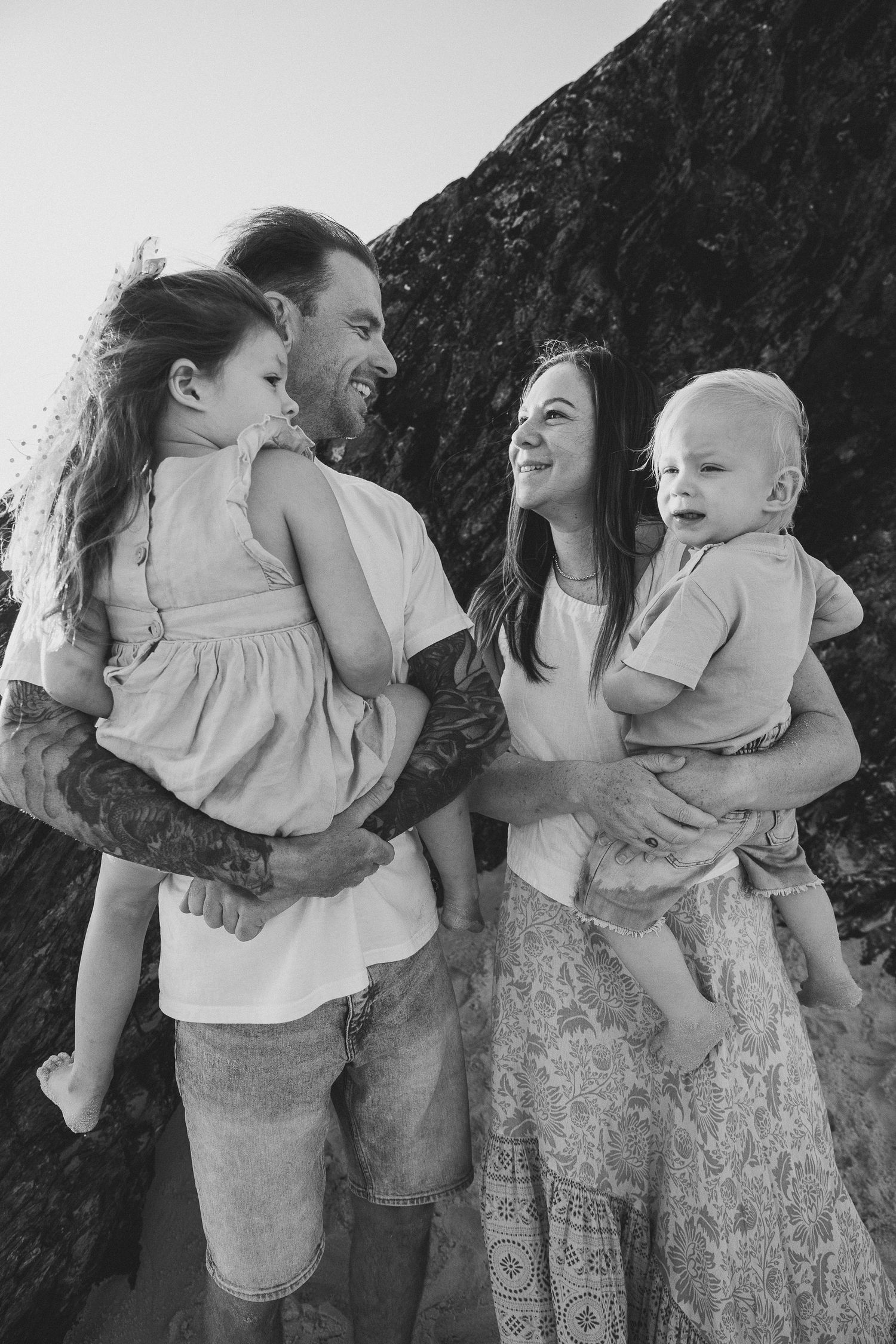 A loving family moment captured in black and white against a dark background.