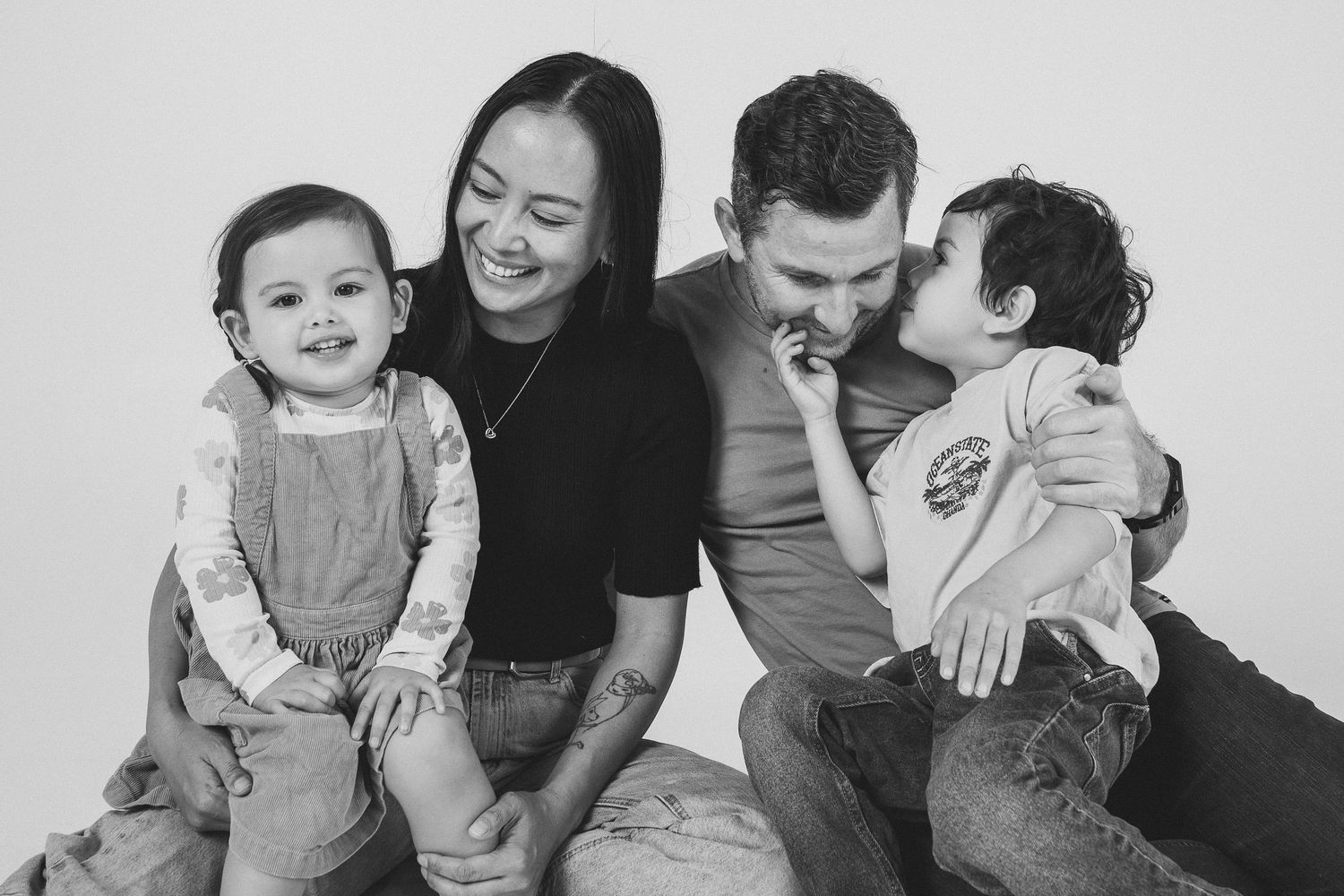 Black and white family portrait series showing loving interactions on white background.