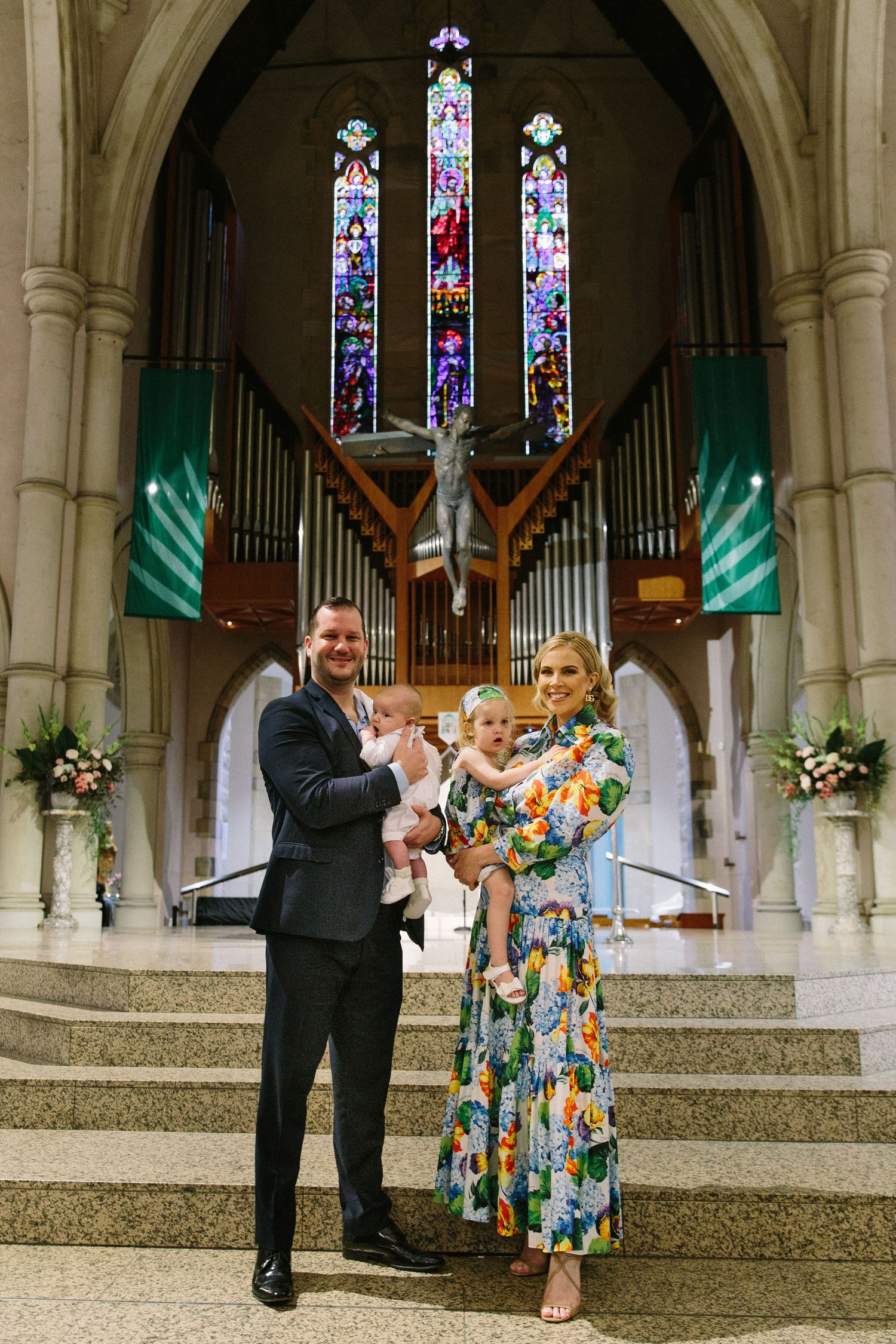 Couple dancing and celebrating in church with stained glass and organ pipes.