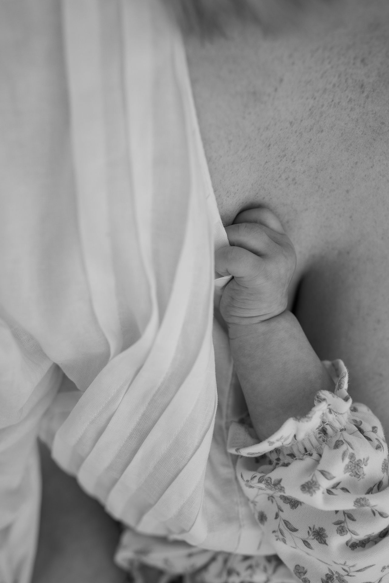 Intimate black and white close-up of nursing mother and baby.