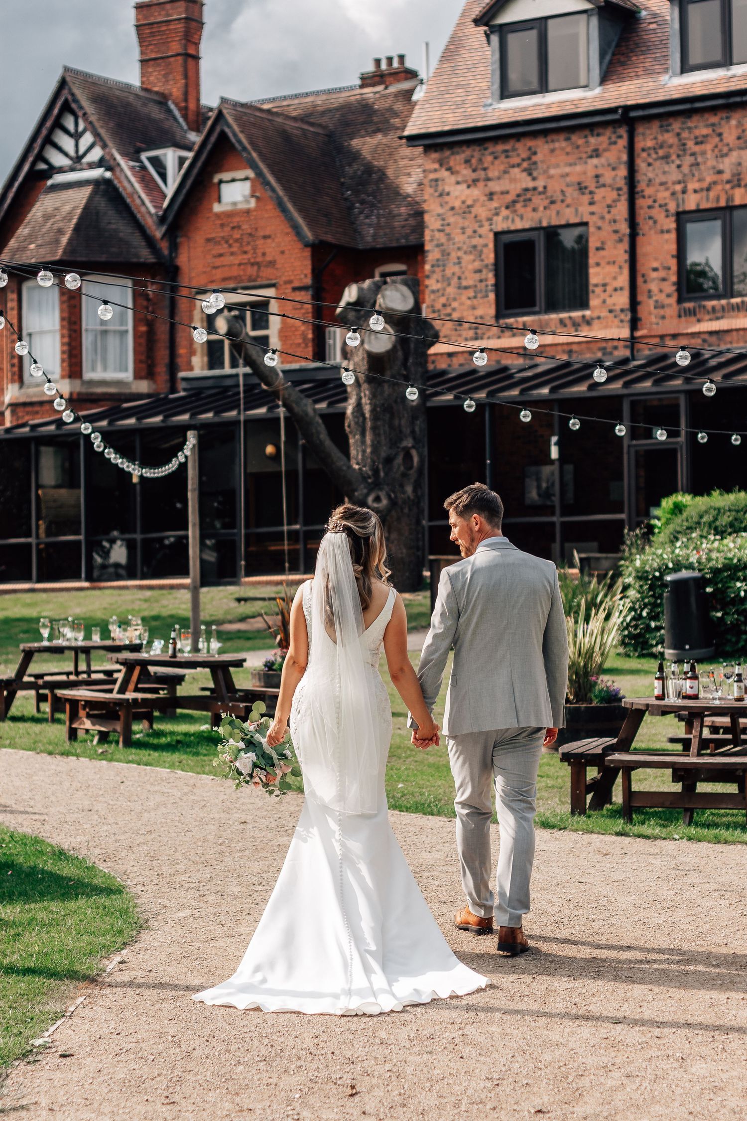 Bride and groom walking towards Mercure Grange Hotel