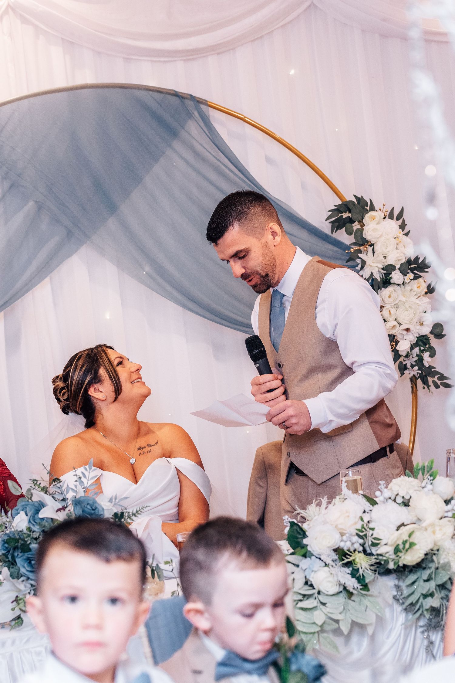 Wedding ceremony setup with floral arch and elegant blue draping.