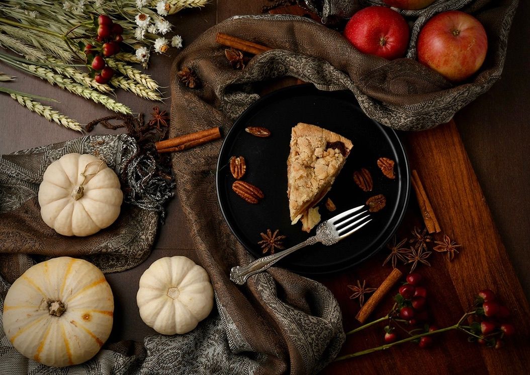 Rustic fall table setting with pie slice, pumpkins and seasonal decorations.