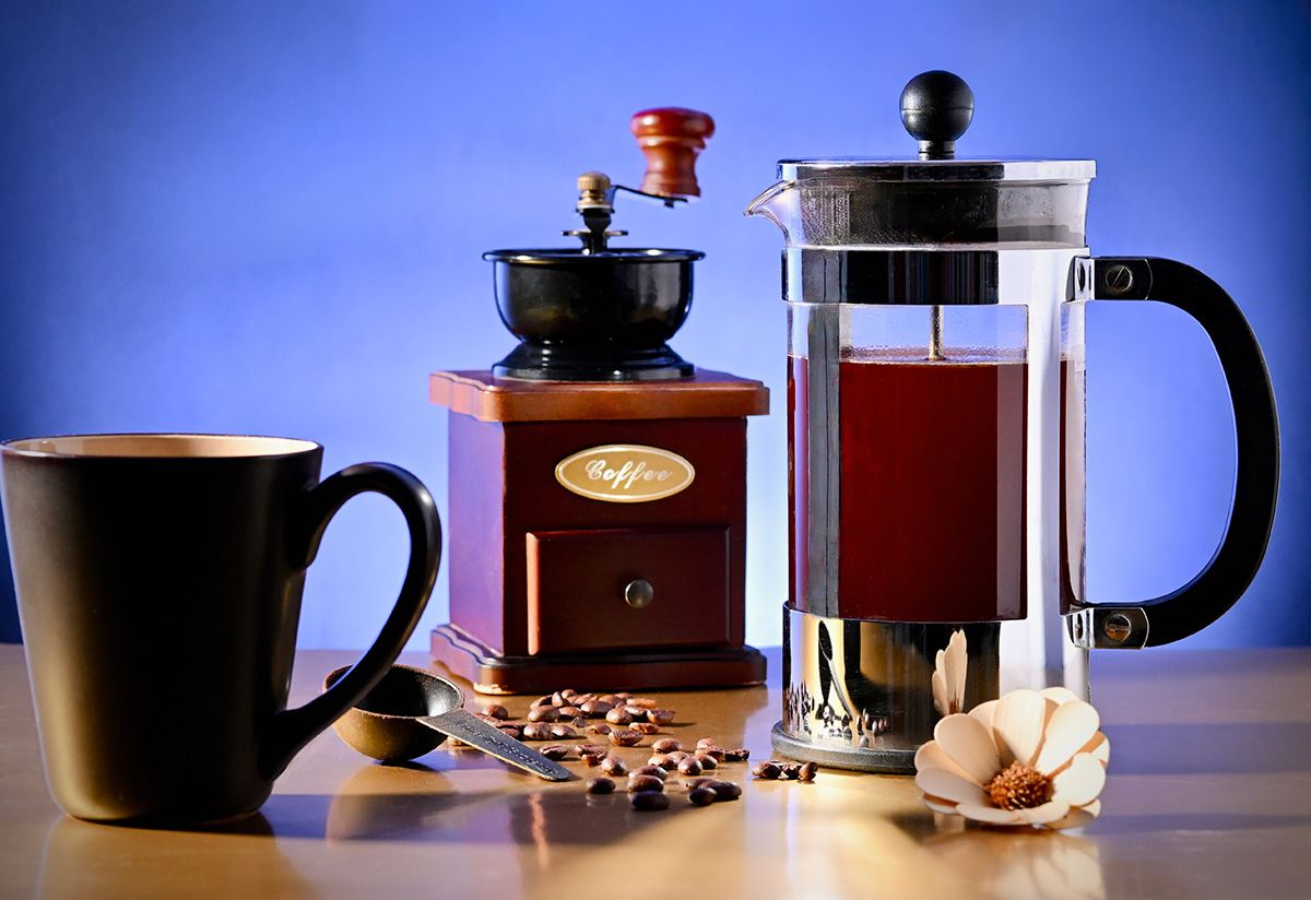 Coffee brewing equipment silhouetted against a vibrant blue background.