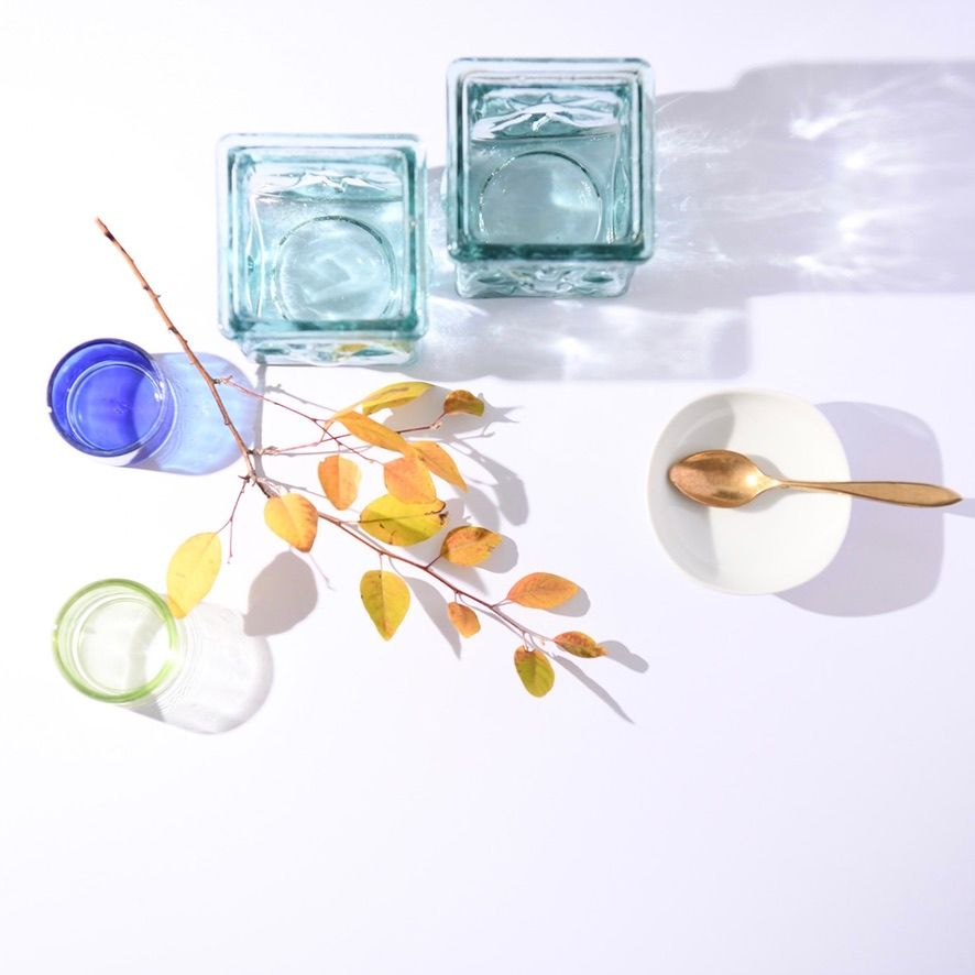Delicate watercolor painting of glass jars and autumn leaves on white background.