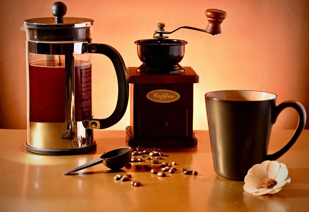 Coffee grinders and cups arranged in warm lighting with an orange glow.