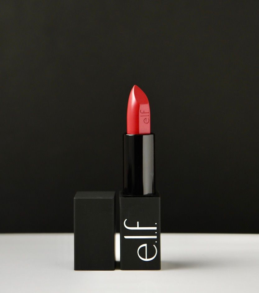 Red lipstick in black ELF brand packaging against dark background.