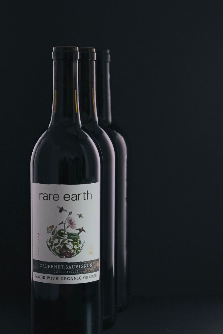 Wine bottles with labels displayed against dark background in minimalist style.