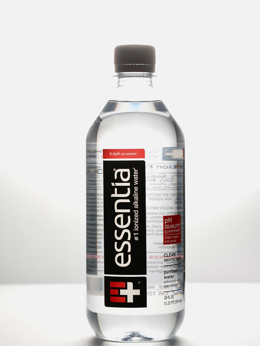 Clear bottle of Essentia water with black and red label on white background.