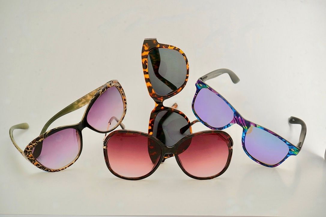 Collection of trendy sunglasses with gradient lenses arranged in a row.