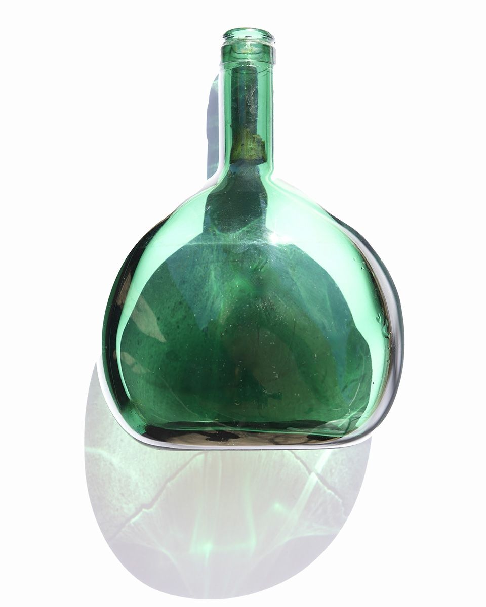 Artistic sequence of green glass bottles with frosted bottoms against a dark background.