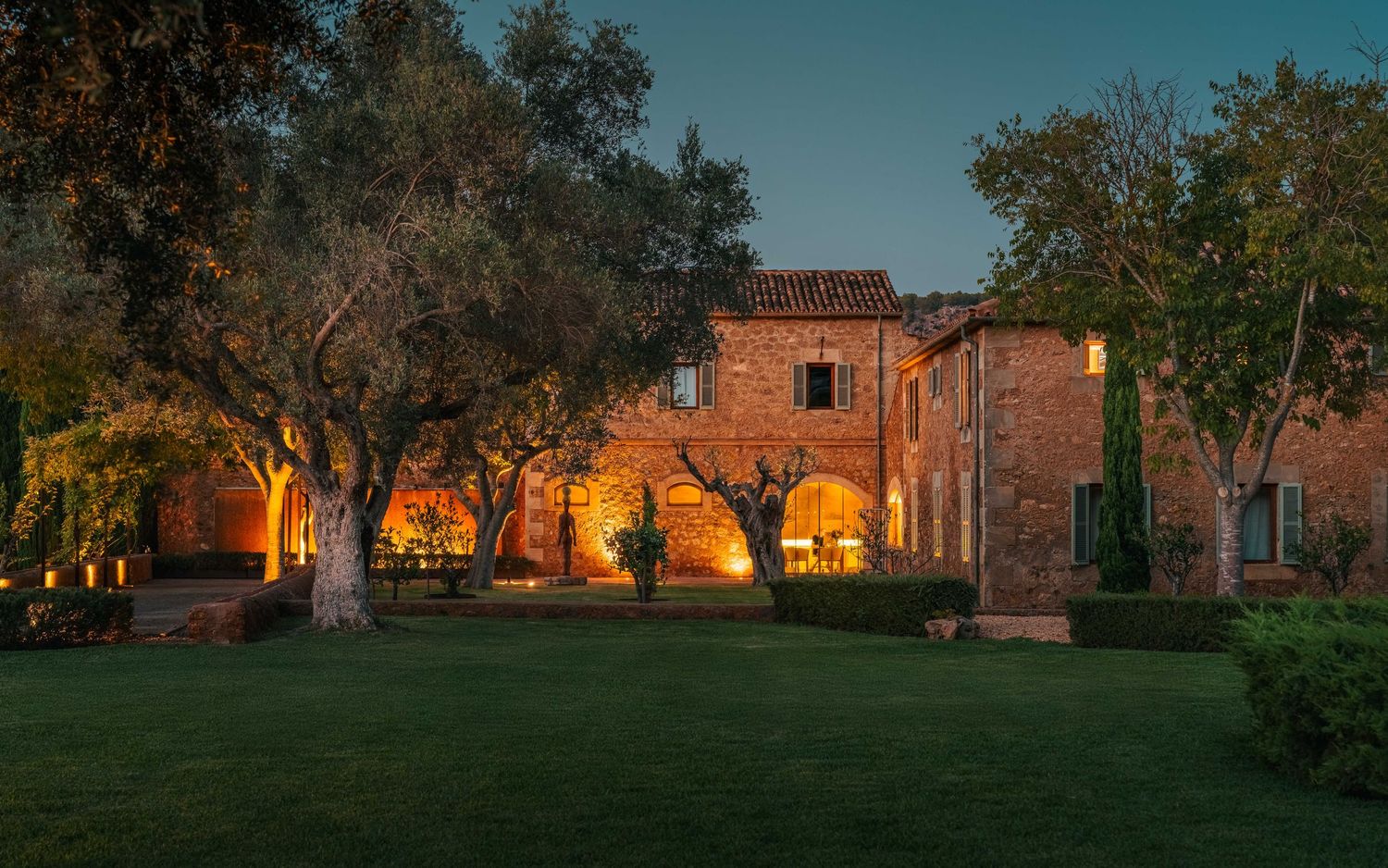 Panoramic view of rustic stone buildings at sunset with golden lighting.