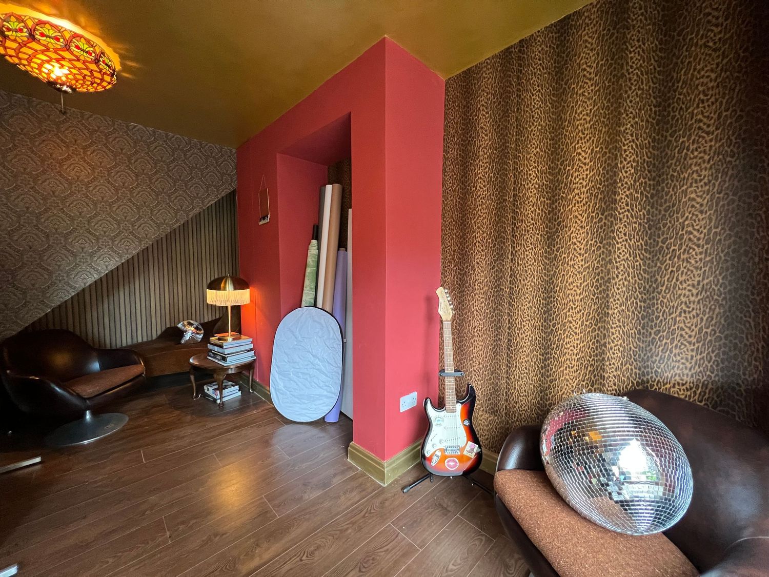 Interior room with red walls and decorative lighting fixtures mounted along the walls.
