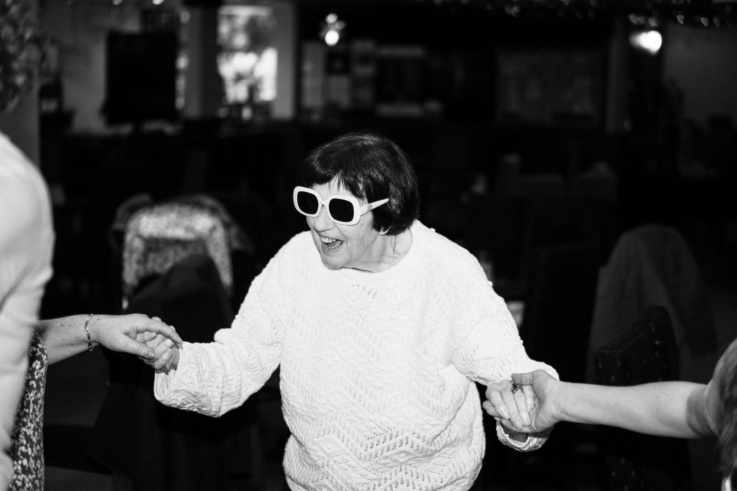 A black and white photo of people dancing at a lively social gathering or party.
