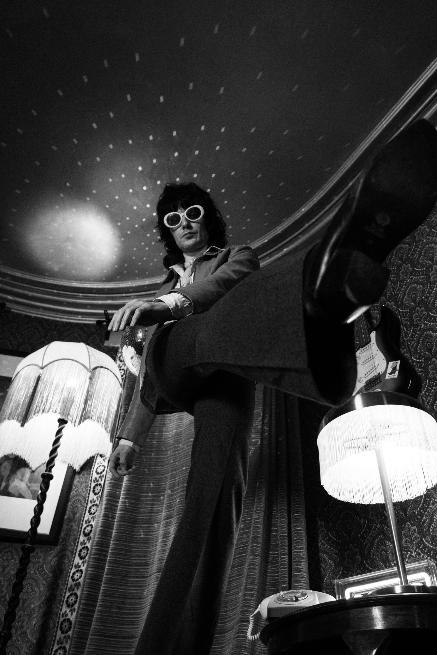 Dramatic low-angle black and white photo under decorative ceiling lights.