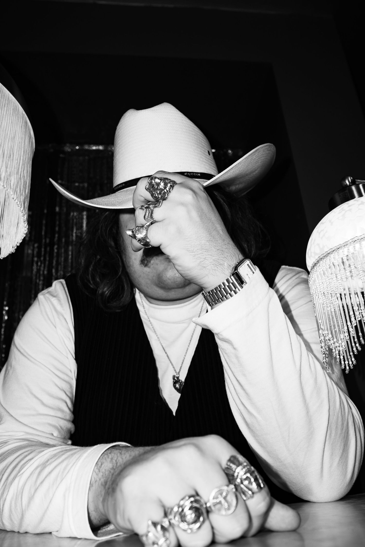 Series of black and white photos showing hands with rings and a watch.