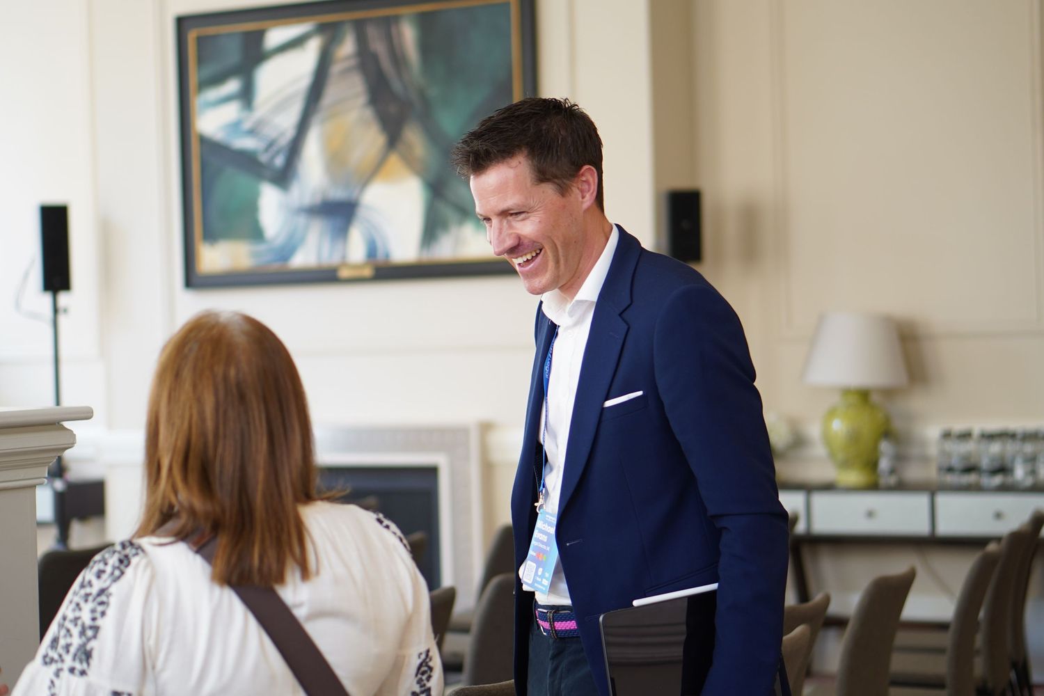 Business professionals in formal attire collaborate and discuss documents in a modern office meeting room.