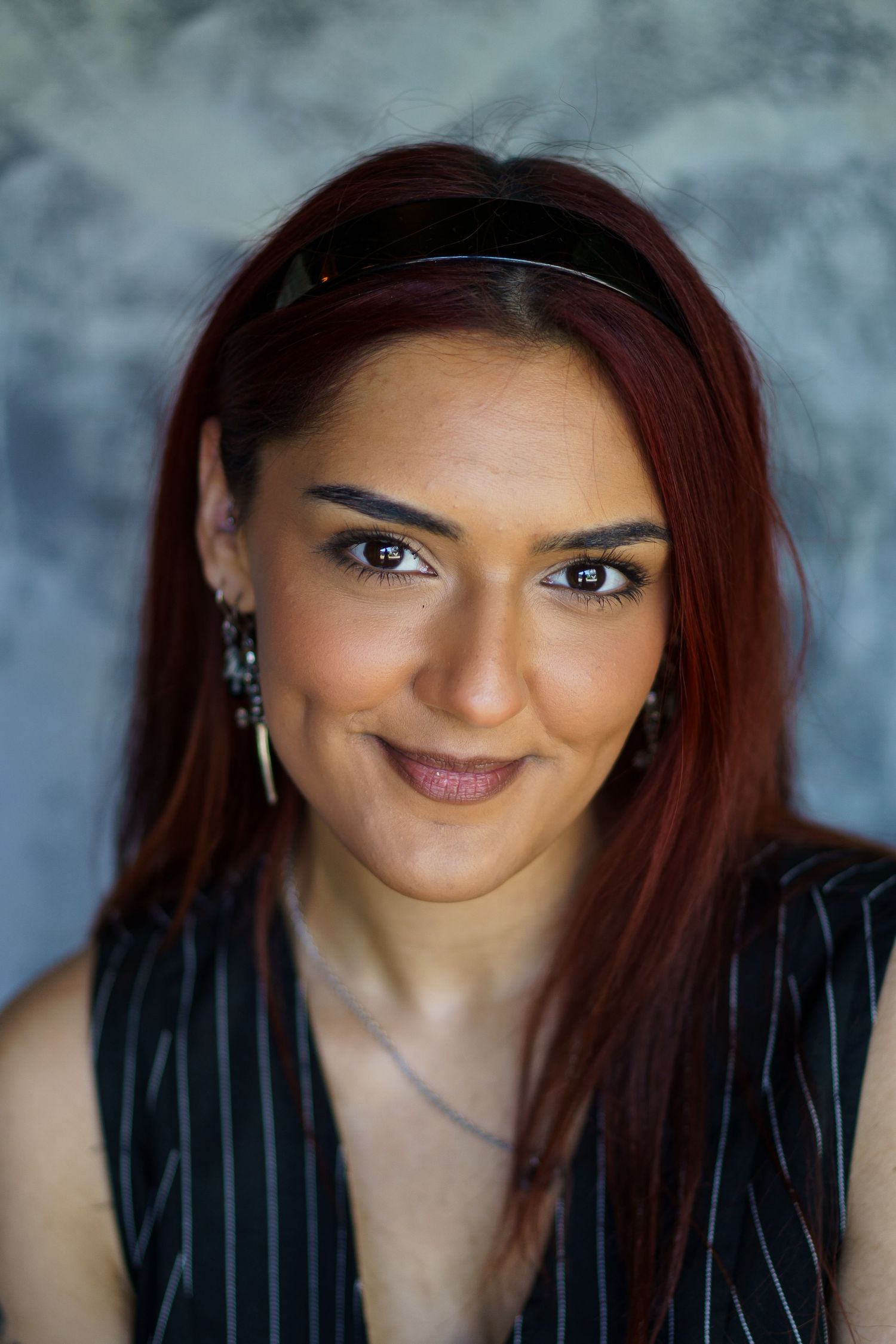 A sequence of six close-up portrait shots showing different playful expressions with burgundy hair against a gray backdrop.