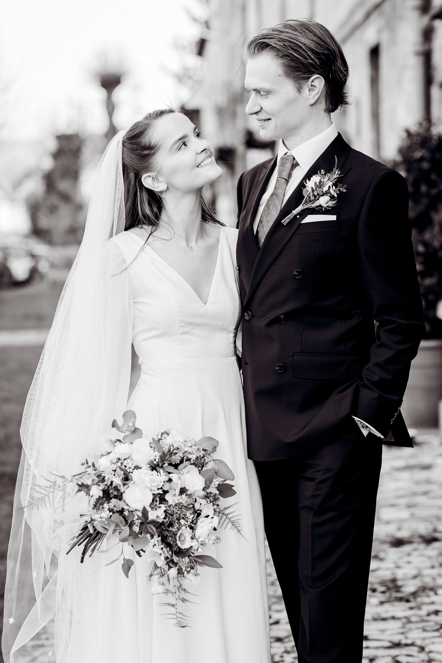 Black and white portrait of bride and groom sharing a romantic moment on wedding day.