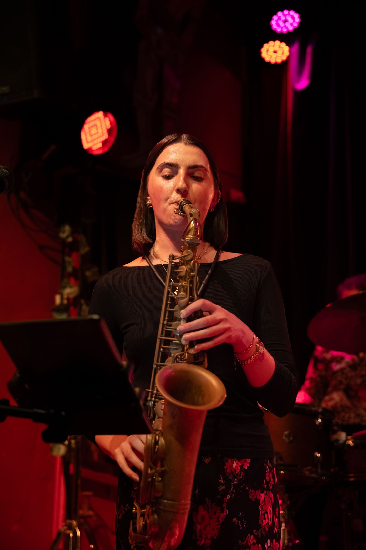 Saxophone player performs on stage bathed in dramatic red lighting during a jazz performance.