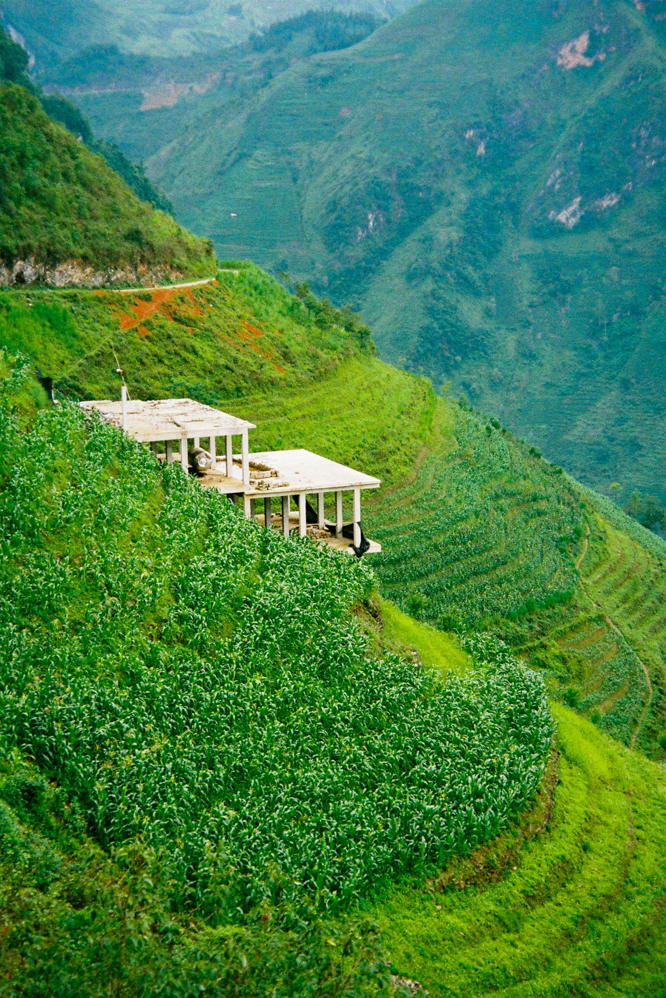 Terraced rice fields and traditional structures nestled in the lush green mountains of Vietnam's countryside.