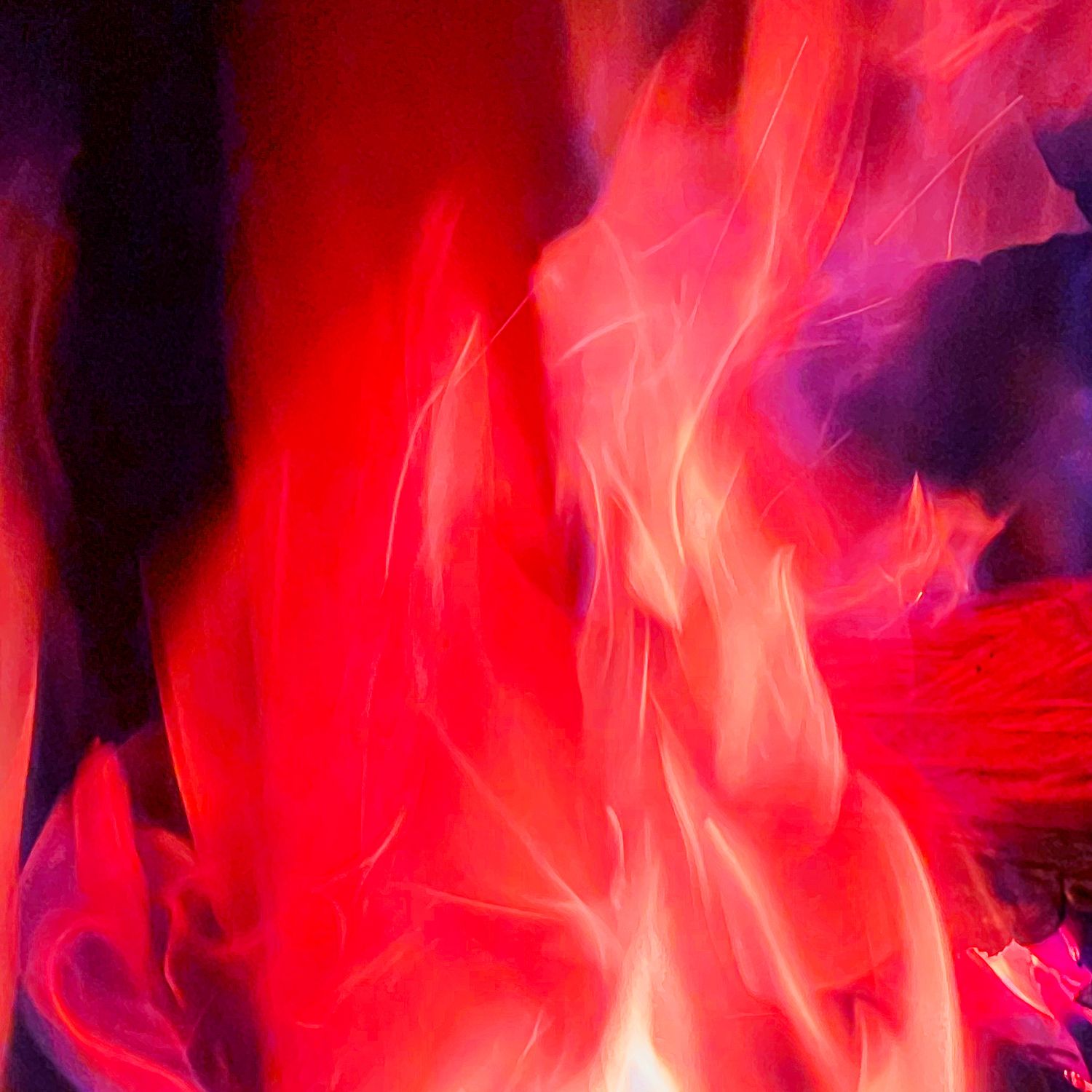 Vivid red and orange flames dance against a dark background, creating an intense and dramatic fire display.