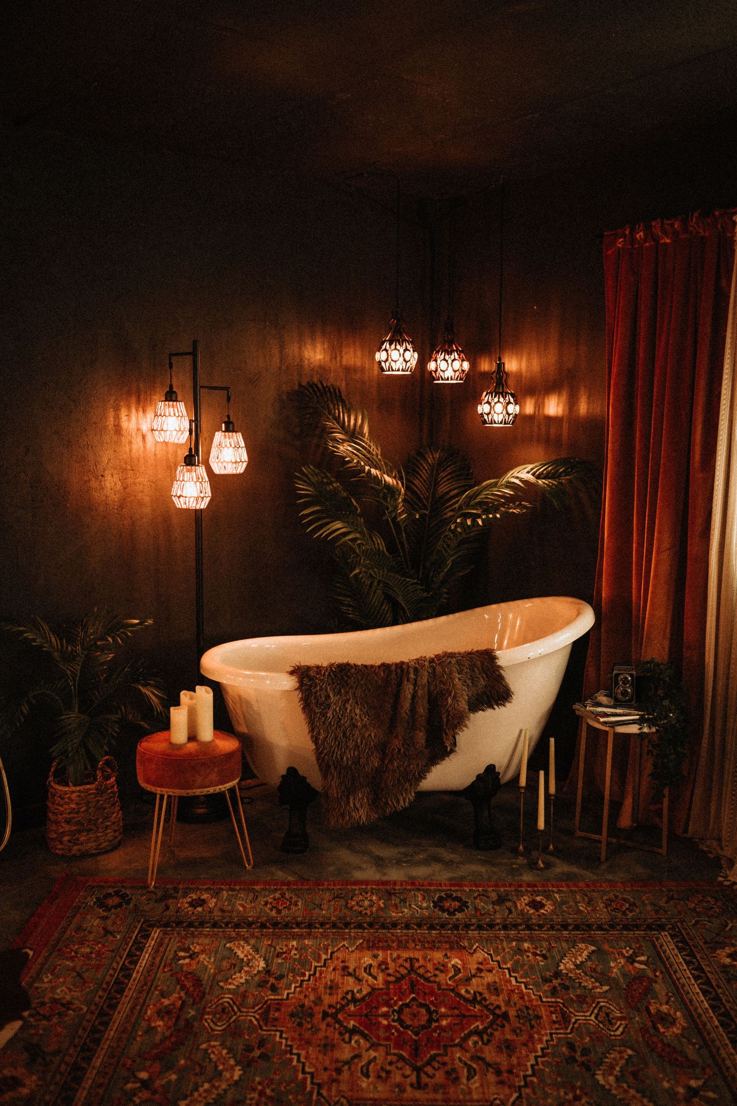 Bohemian styled room with oriental rug, potted palms, and warm mood lighting.
