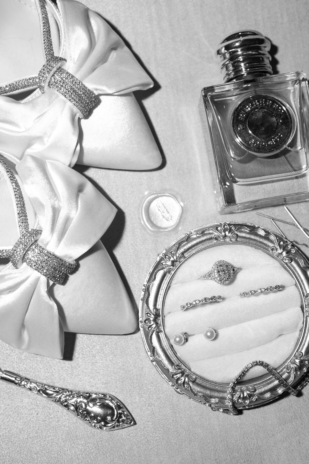 Black and white photograph showing vintage silver jewelry pieces including bracelets and necklaces arranged on a light surface.