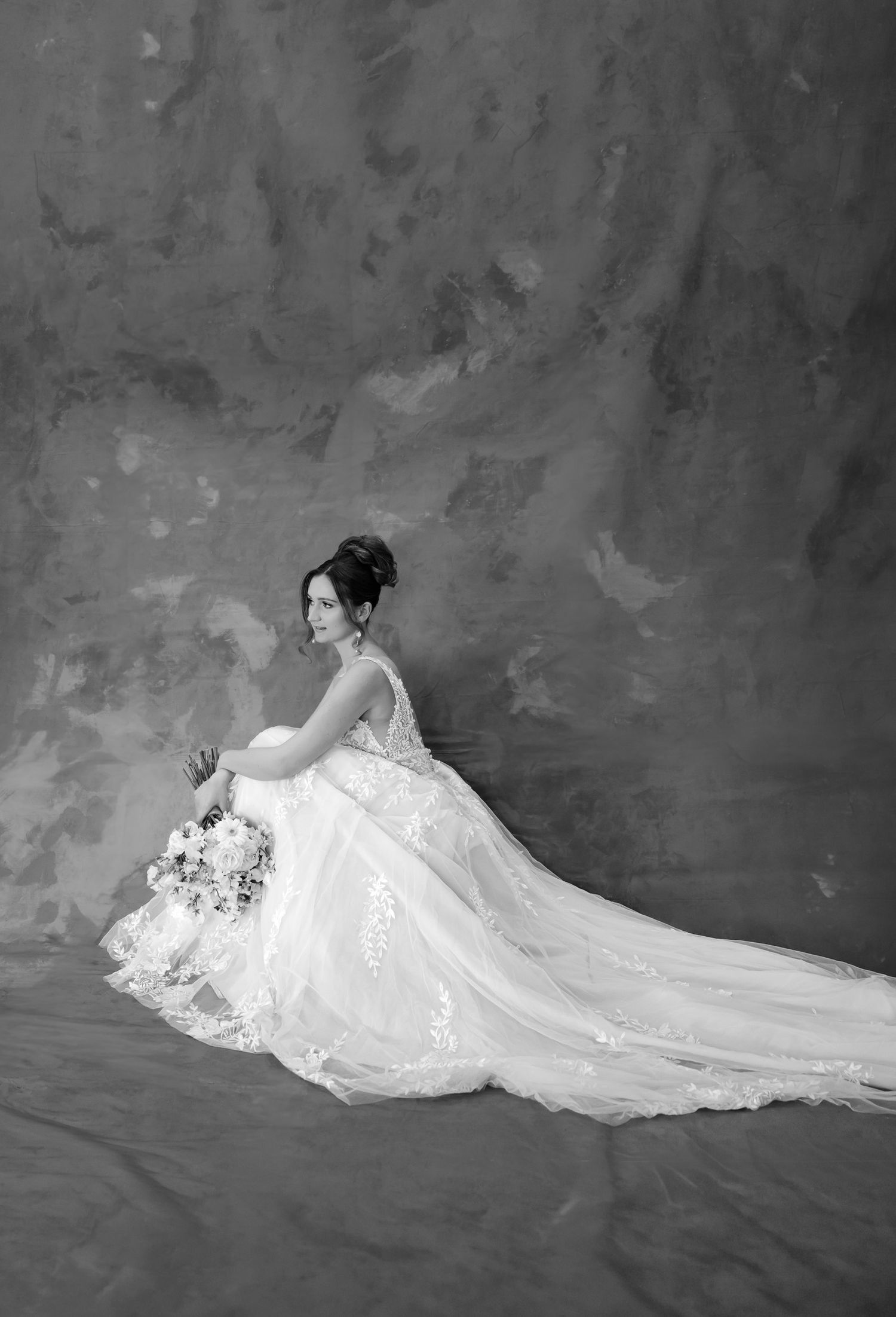 A black and white artistic bridal portrait series showing a flowing wedding gown against a textured backdrop.