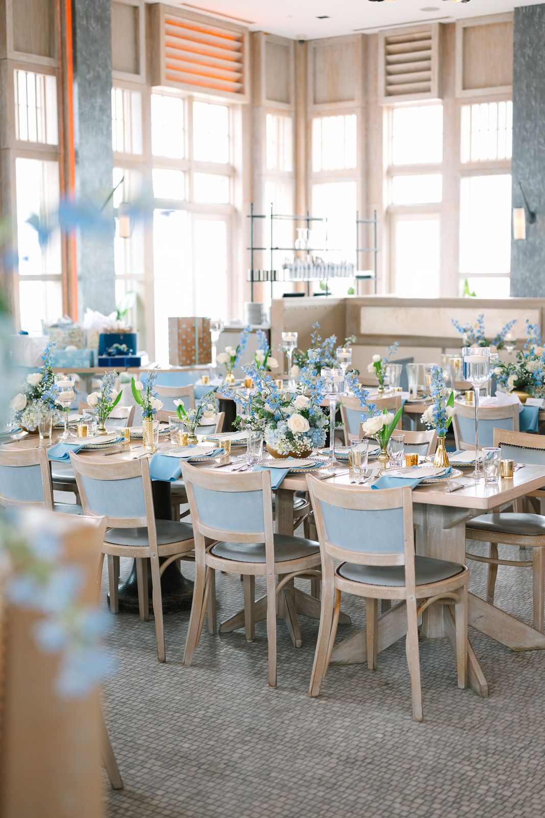 Elegant NJ event venue with white and blue table settings arranged in a bright room with large windows.