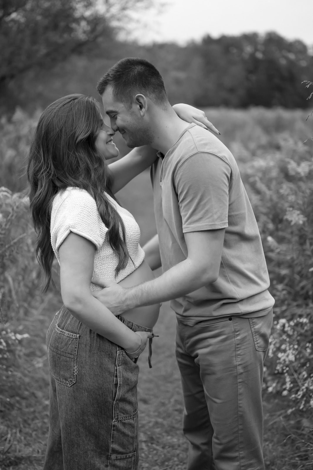 A romantic black and white photo sequence shows a couple sharing tender moments in a field of wildflowers.