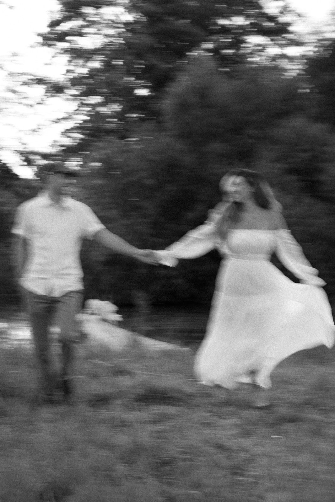 A blurry black and white sequence shows two people dancing together outdoors in a whimsical, spinning motion.