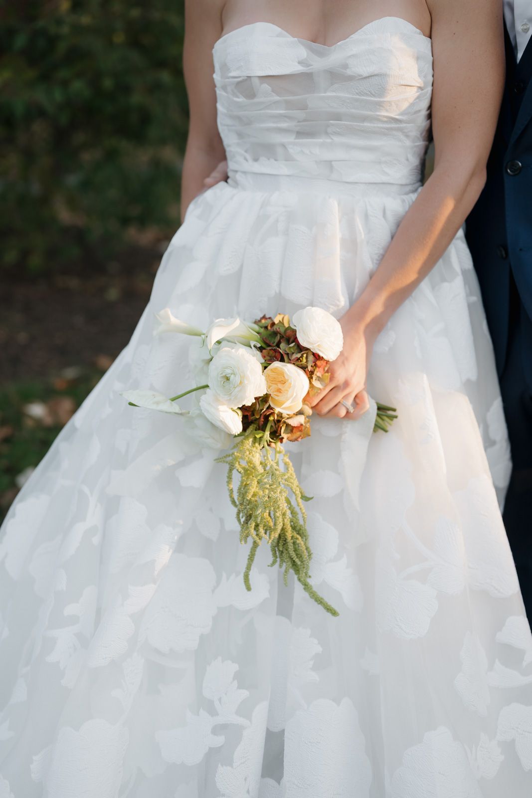 A series of wedding dress details showing a white gown with a delicate bouquet of cream and white flowers.