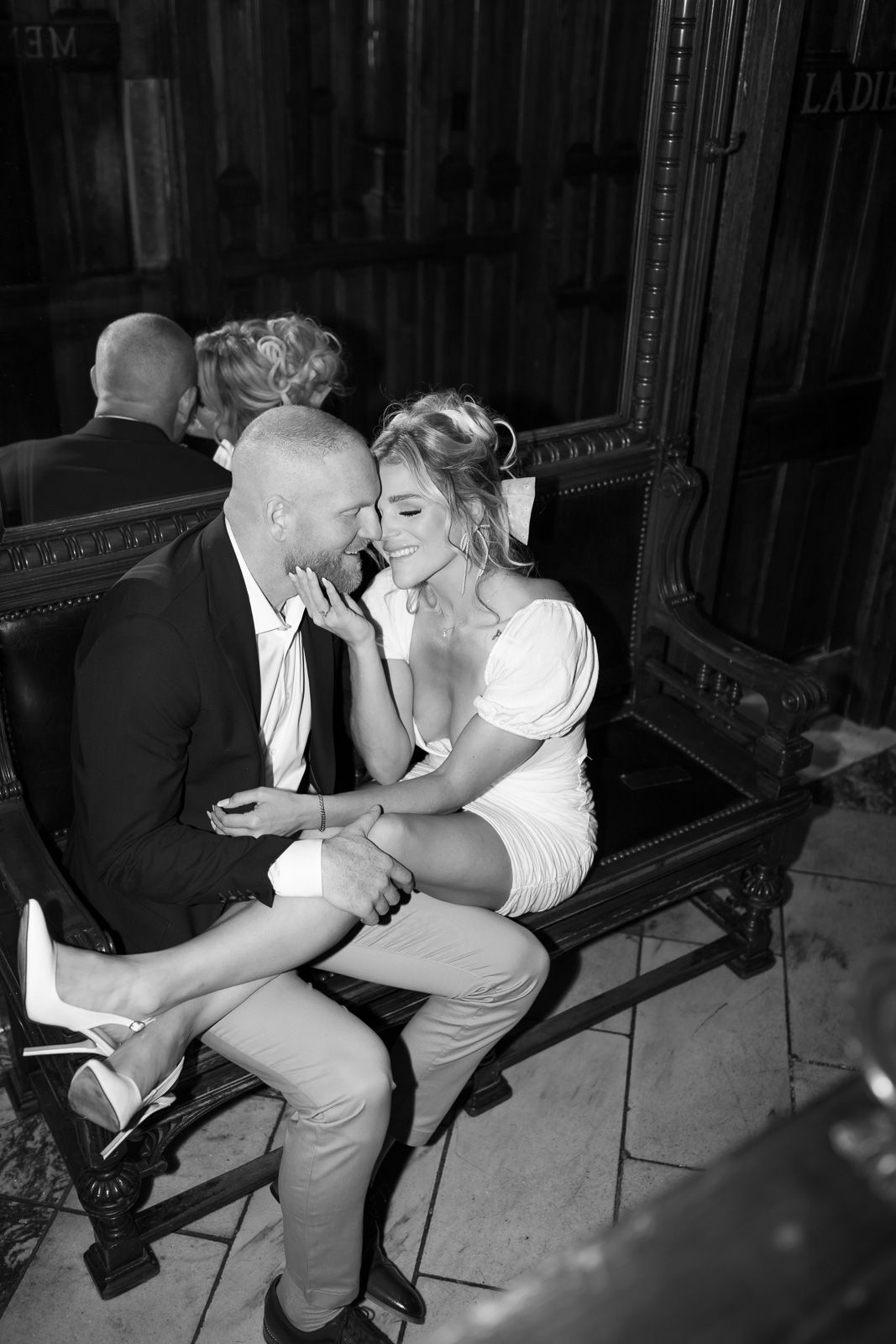 A romantic black and white photo sequence showing a couple sitting on a bench in four progressive intimate moments.