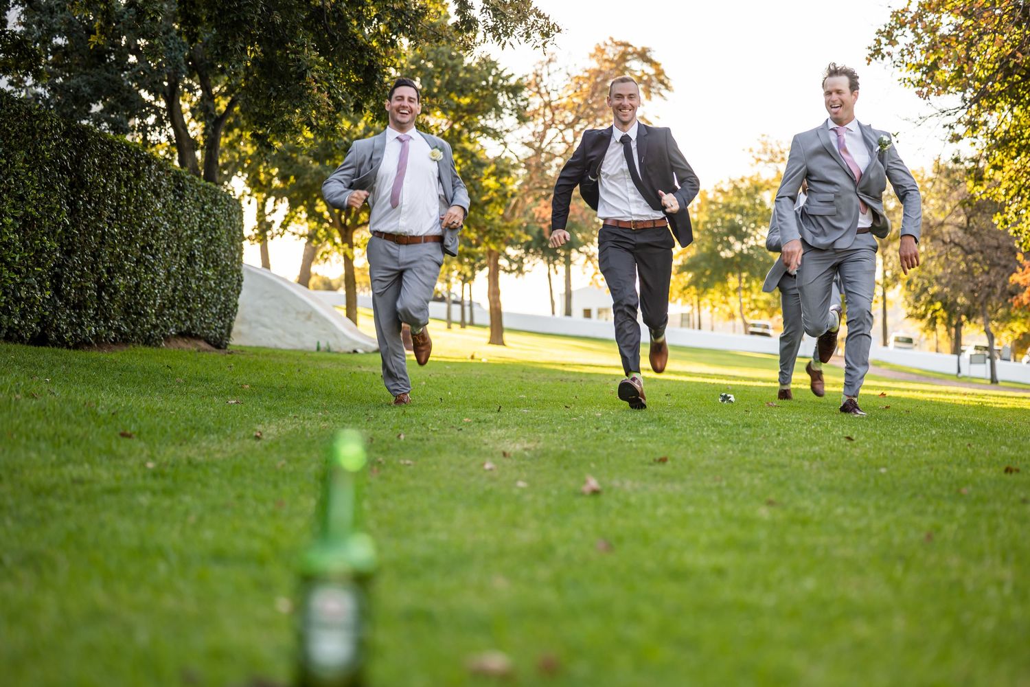 People play lawn games on lush green grass during a sunny outdoor celebration.