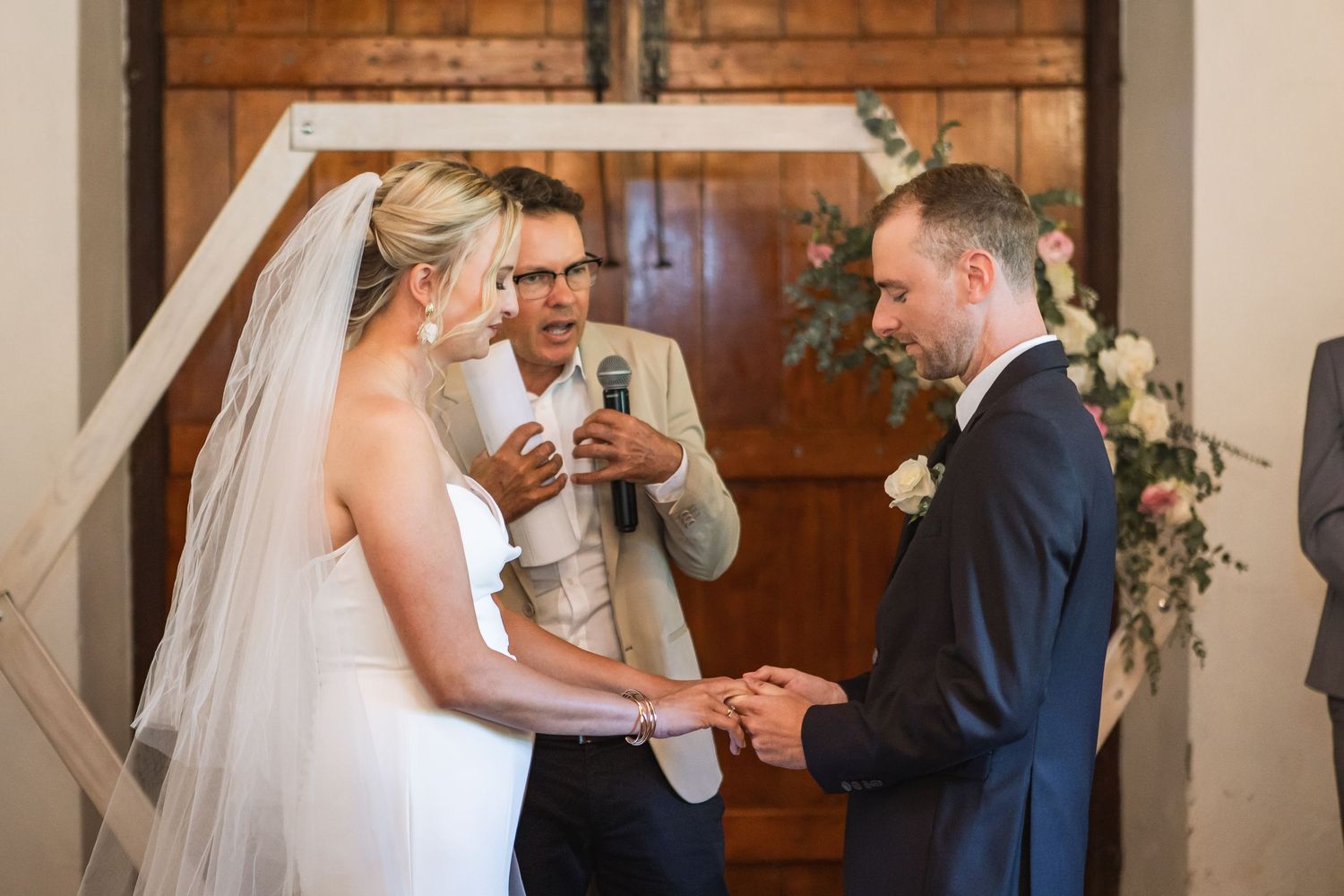 Wedding ceremony moments captured inside a rustic brick-walled venue.
