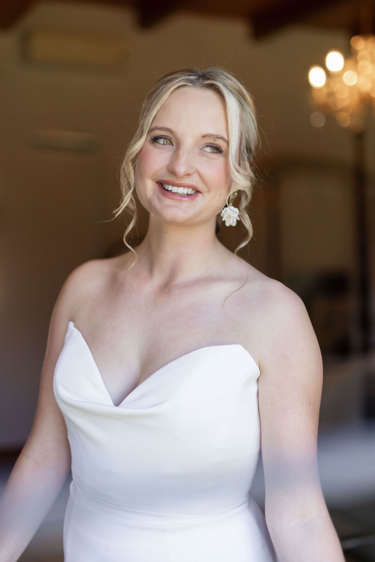 Close-up portrait shots of a bride in a white wedding dress with an elegant neckline and natural makeup.