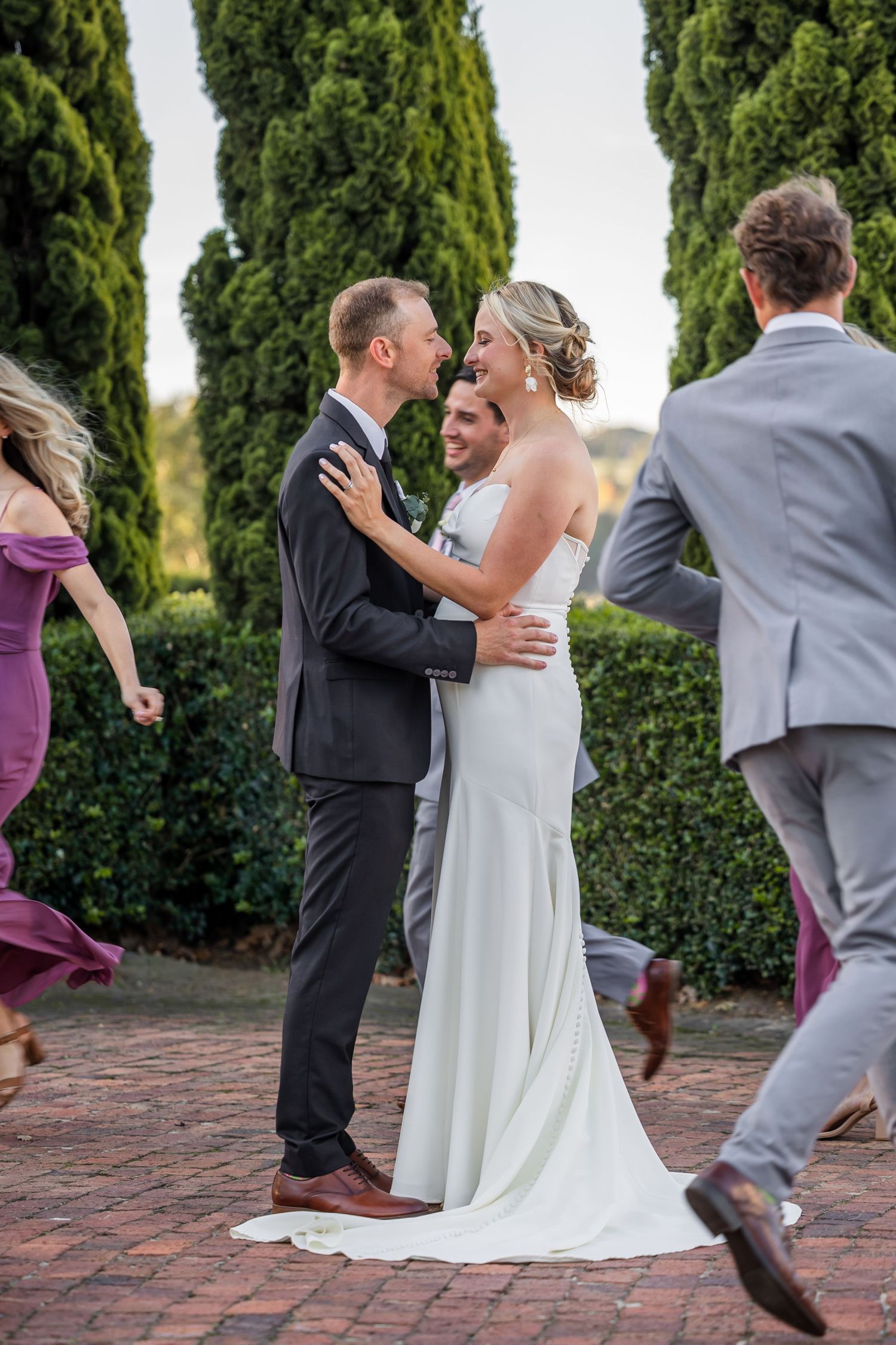 Sequence of wedding photos showing a couple dancing on a brick patio surrounded by greenery.