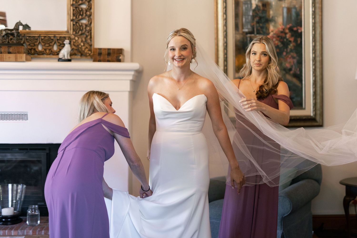 Wedding party preparations with bridesmaids in purple dresses helping the bride get ready.