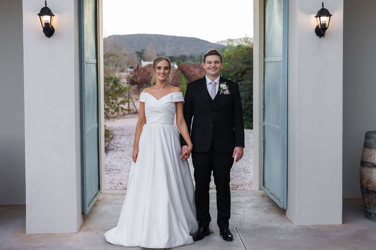 Bride and groom stand together in a grand doorway with mountain views at their wedding venue.