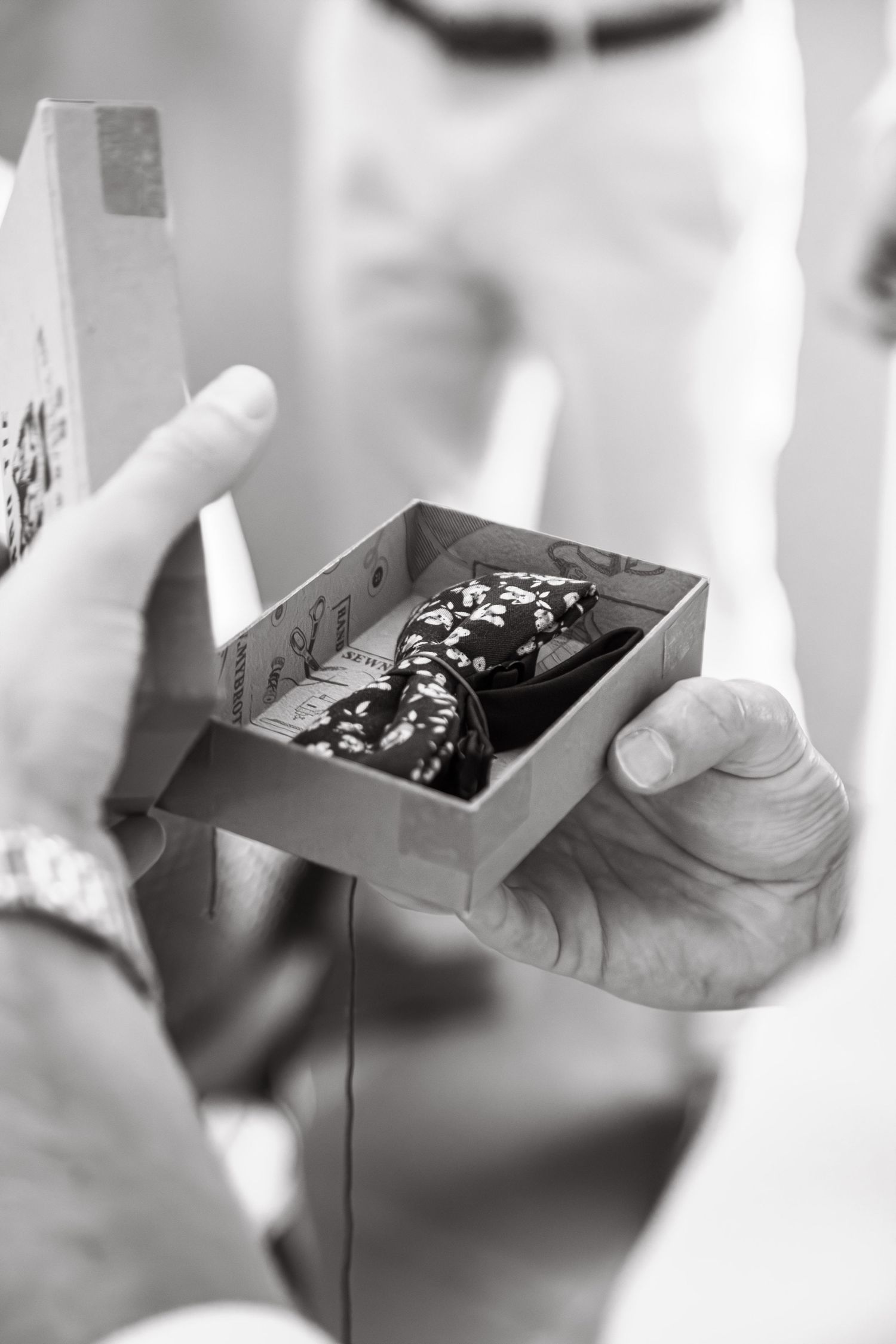Close-up of hands holding small black jewelry boxes.