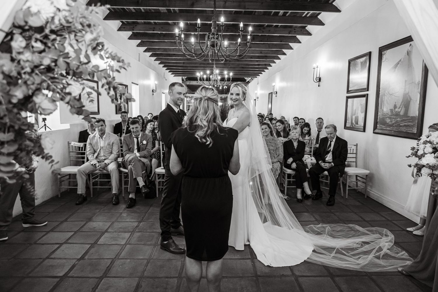 Wedding ceremony space with guests seated in rows and white decor.