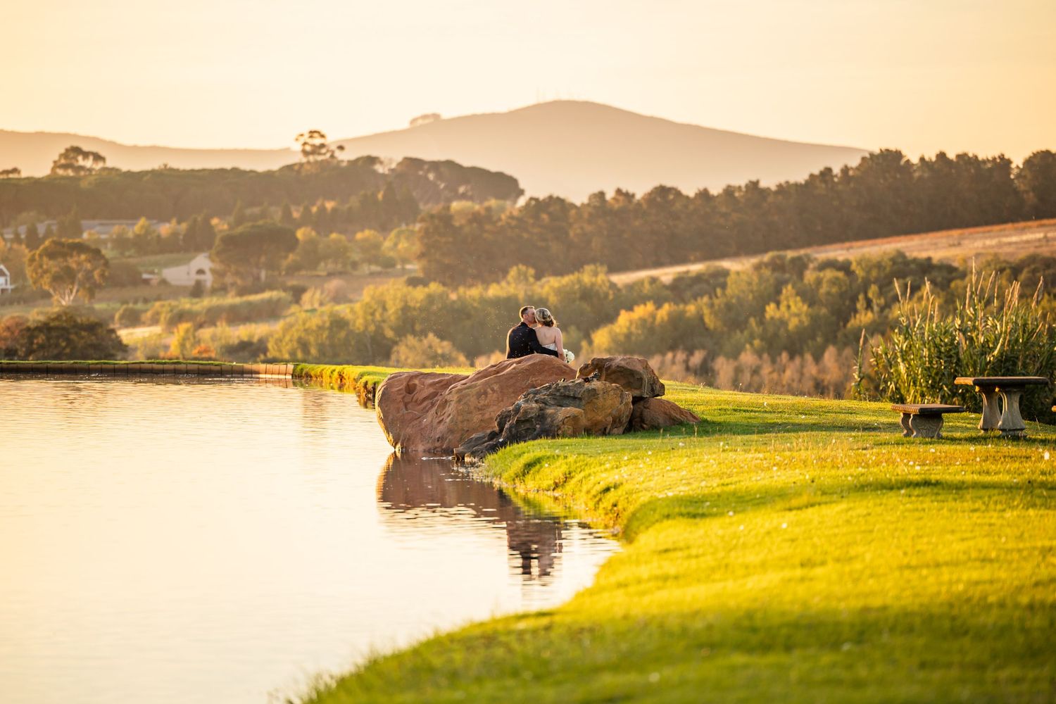 Panoramic sunset view of a lakeside wedding venue in rolling hills.