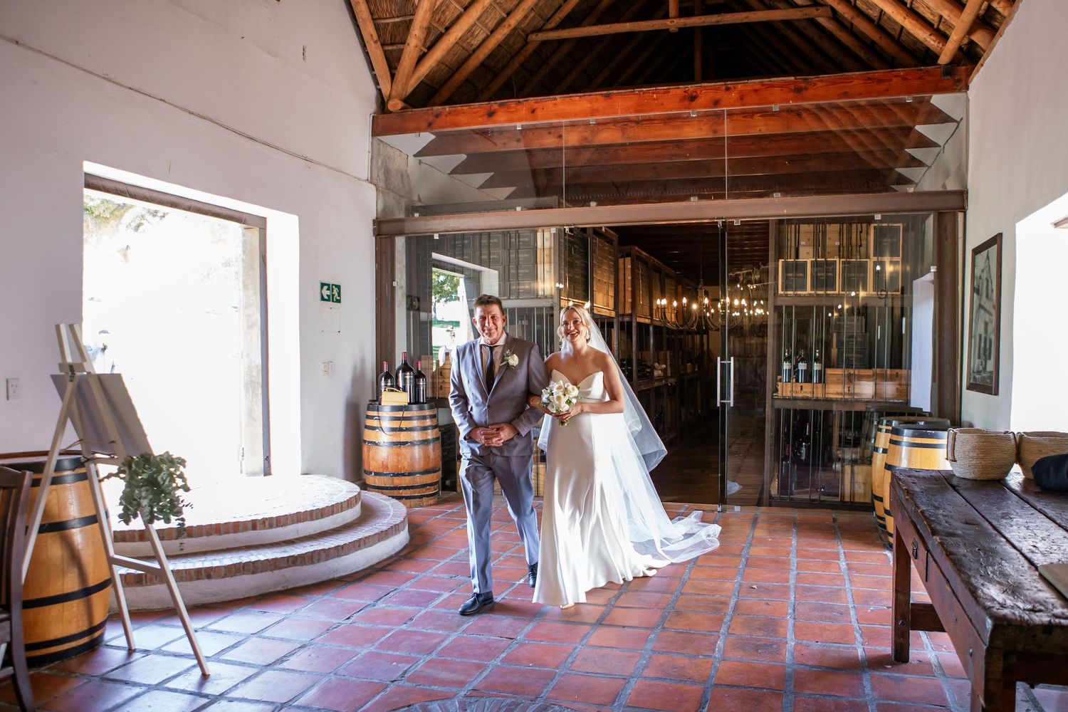 Panoramic view of a rustic wedding venue with exposed wooden beams and brick walls.