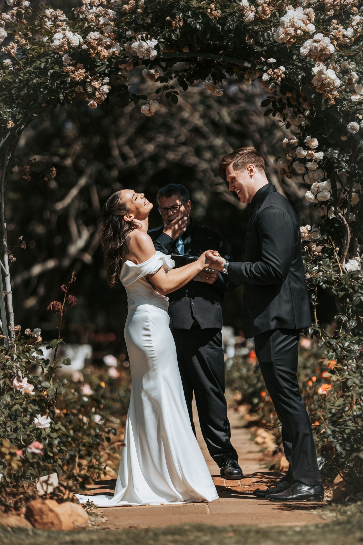 A couple dances together under blooming cherry blossom trees in a romantic outdoor garden setting.